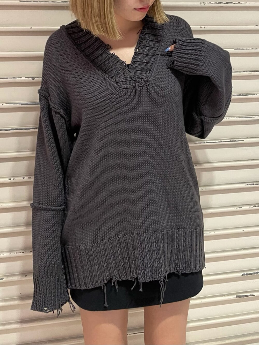 ブラック系のスカート、グレー系のニット/セーターを着用したレディースの秋コーディネートの5枚目の写真