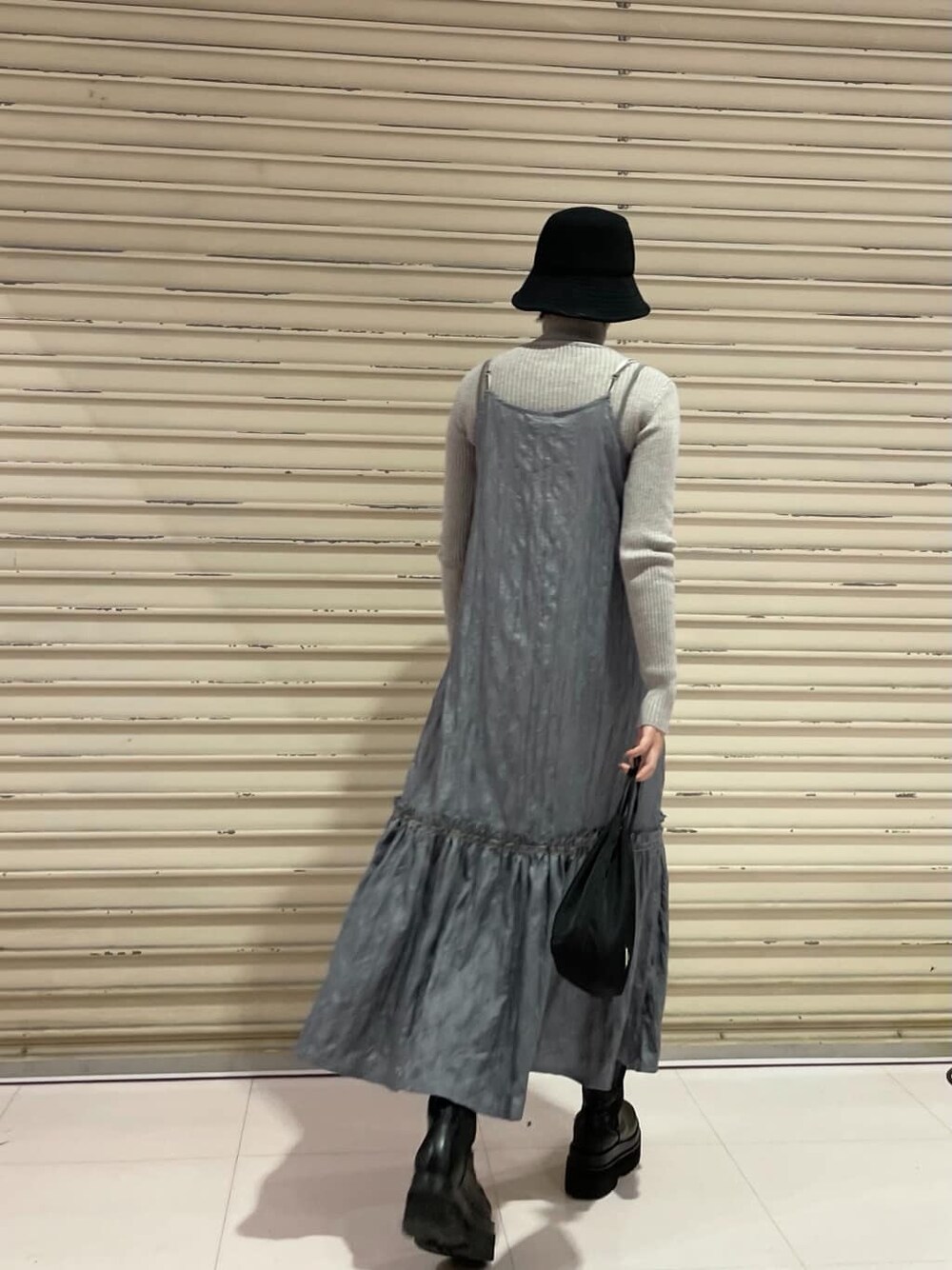 グレー系のニット/セーター、グレー系のワンピース、ブラック系のハットを着用したレディースの冬コーディネートの4枚目の写真