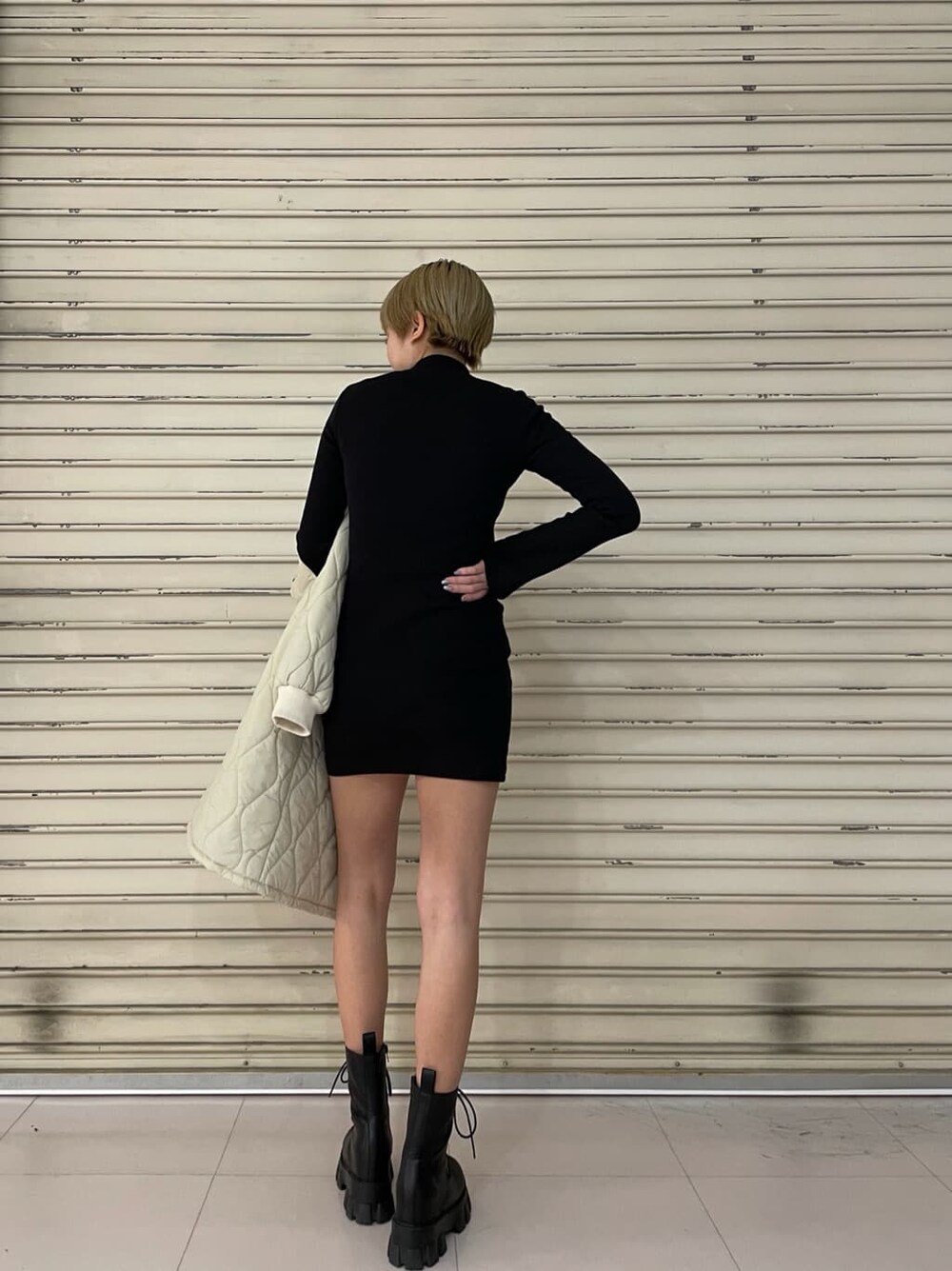 ホワイト系のモッズコート、ブラック系のワンピース、ブラック系のブーツを着用したレディースの春コーディネートの6枚目の写真