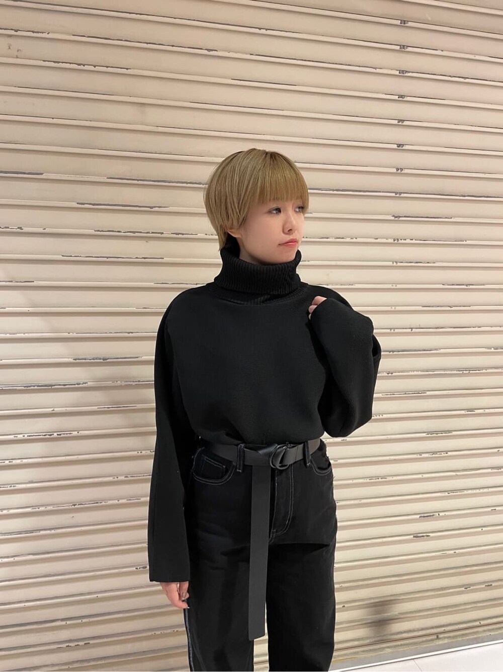 ブラック系のデニムパンツ、ブラック系のニット/セーター、ホワイト系のローファーを着用したレディースの秋コーディネートの6枚目の写真