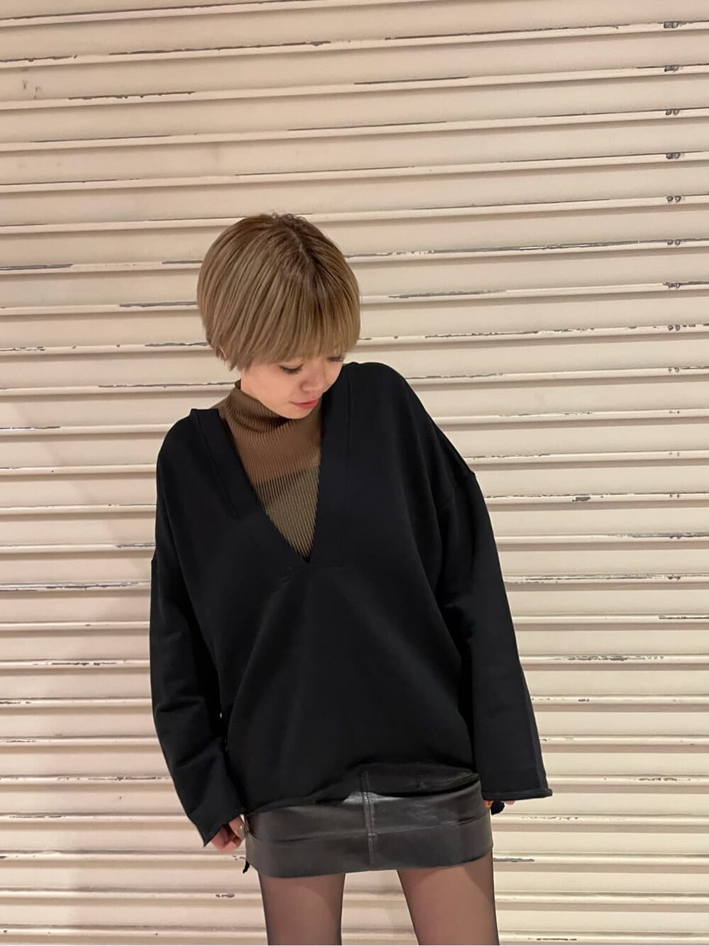 ブラック系のブーツ、ブラック系のスカート、ブラウン系のTシャツ/カットソーを着用したレディースの冬コーディネートの4枚目の写真