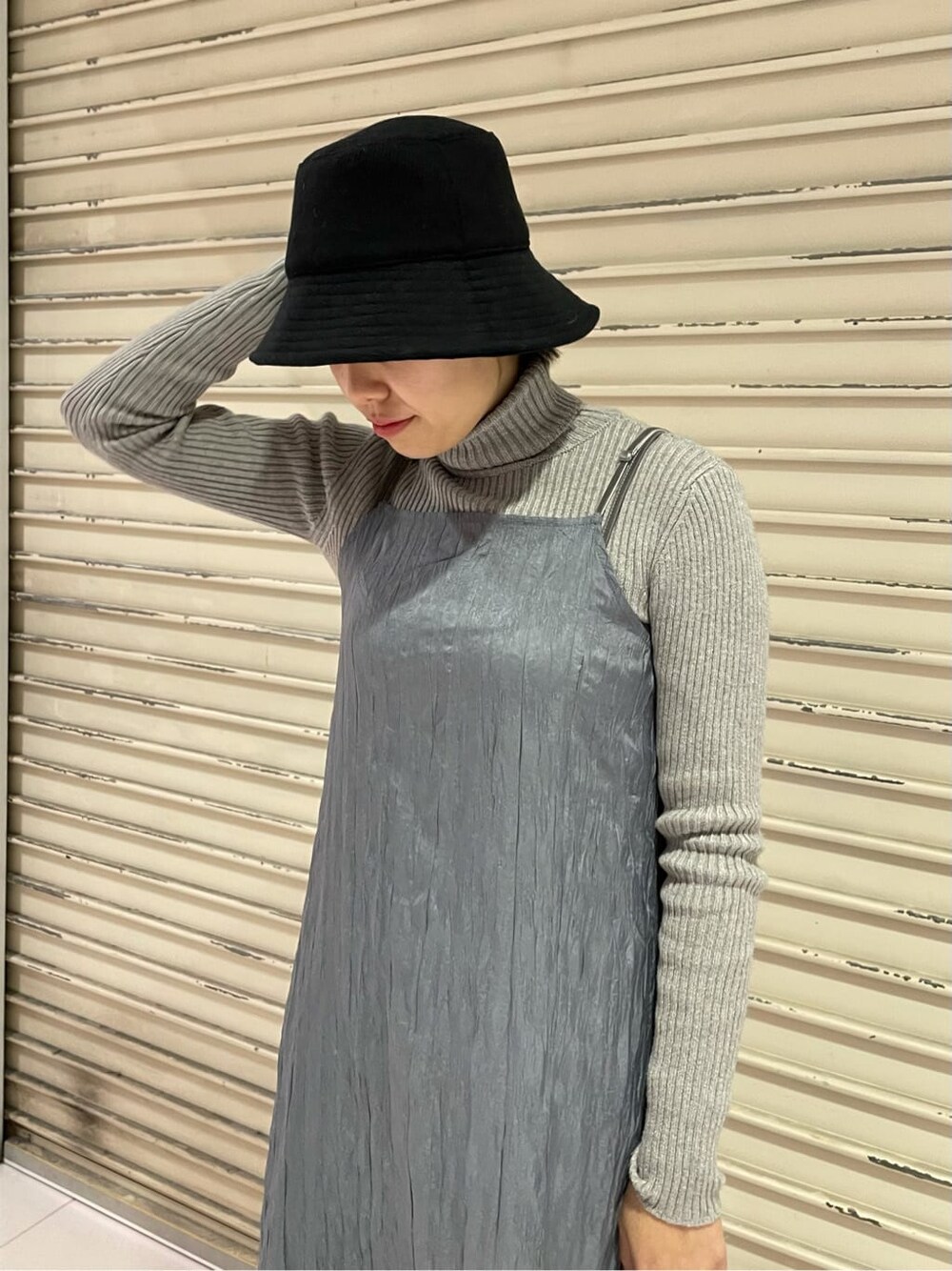 グレー系のニット/セーター、グレー系のワンピース、ブラック系のハットを着用したレディースの冬コーディネートの6枚目の写真