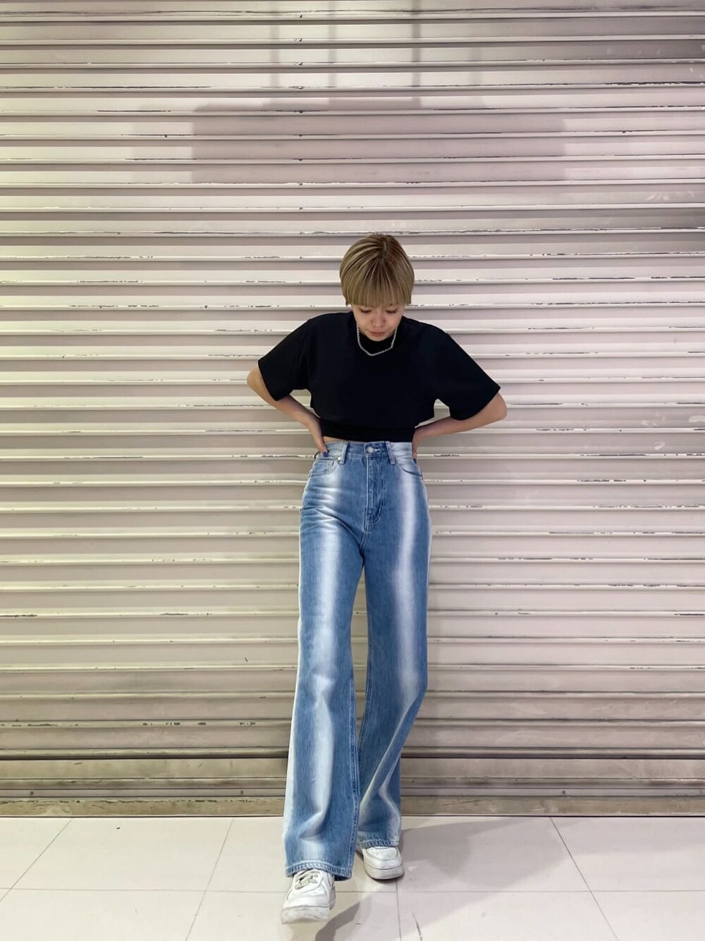 ブルー系のデニムパンツ、ブラック系のTシャツ/カットソー、シルバー系のネックレスを着用したレディースの春コーディネートの3枚目の写真