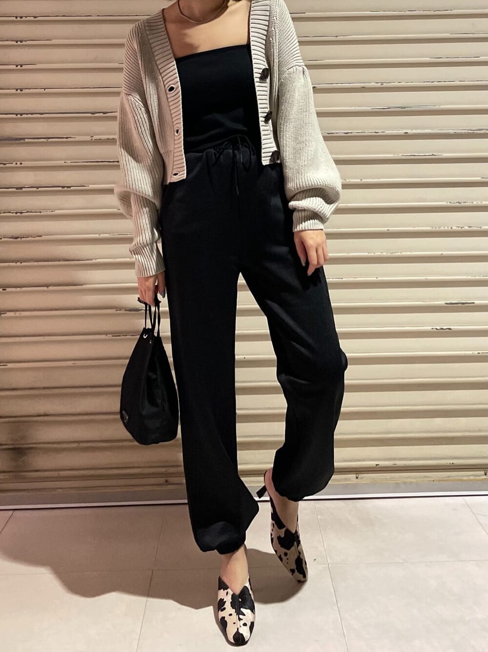 その他のパンプス、ブラック系のその他パンツ、ベージュ系のカーディガン/ボレロを着用したレディースの秋コーディネートの2枚目の写真