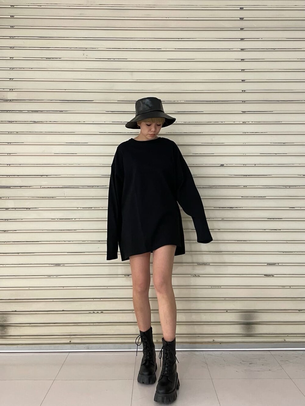 ブラック系のブーツ、ブラック系のTシャツ/カットソー、ブラック系のハットを着用したレディースの冬コーディネートの3枚目の写真