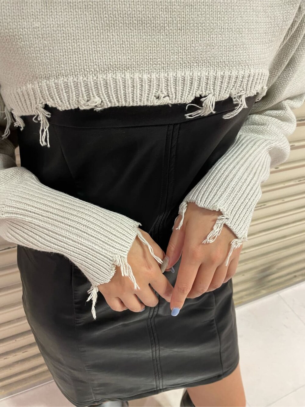 ブラック系のワンピース、ブラック系のブーツ、ホワイト系のニット/セーターを着用したレディースの秋コーディネートの4枚目の写真