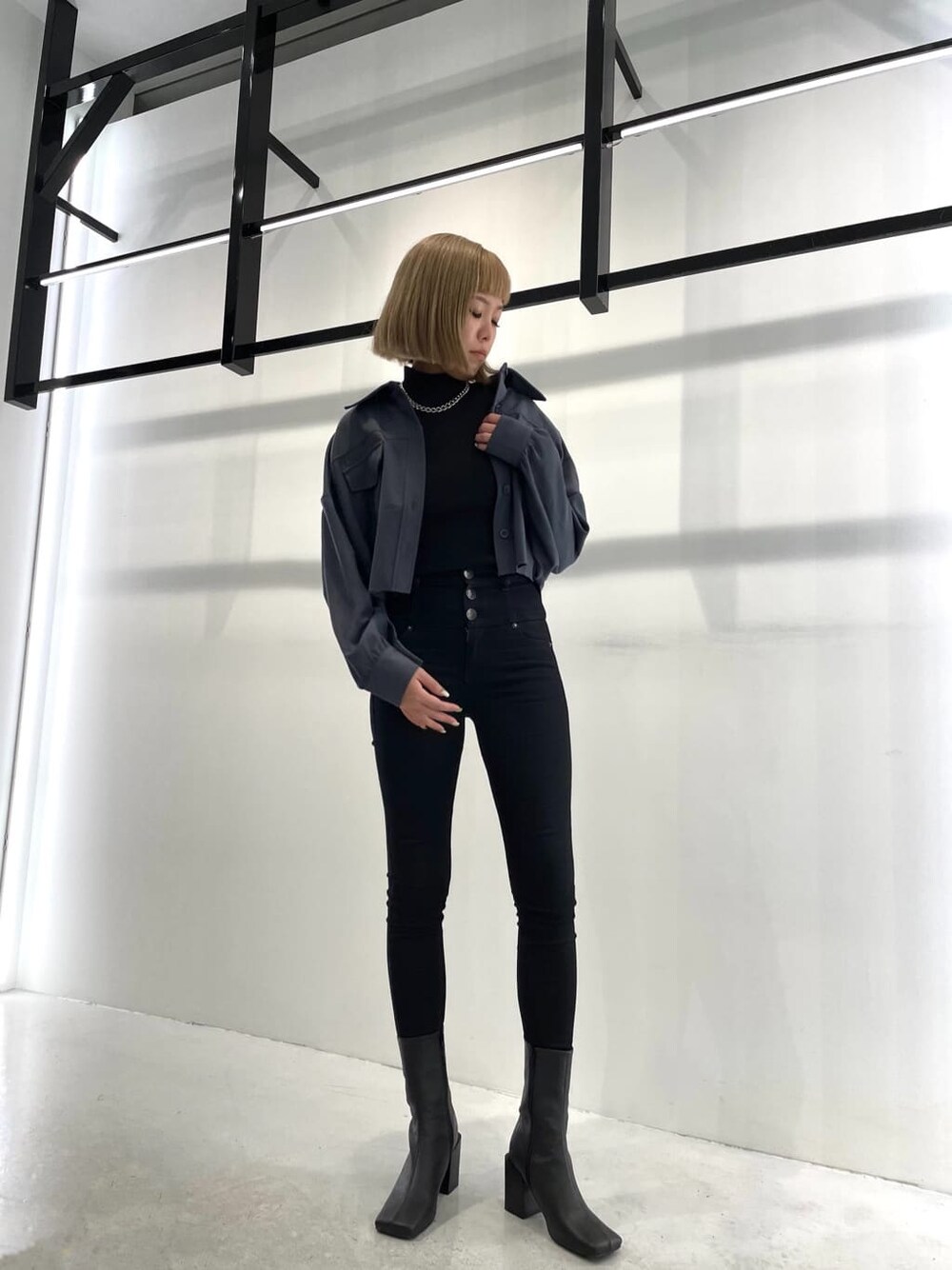 ブルー系のテーラードジャケット、ブラック系のブーツ、ブラック系のデニムパンツを着用したレディースの夏コーディネートの2枚目の写真