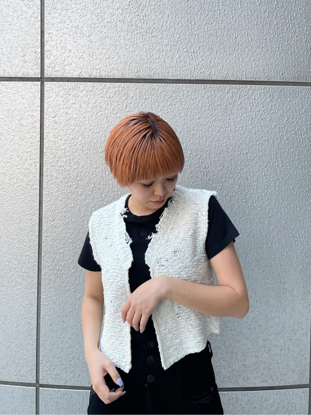 ブラック系のデニムパンツ、ホワイト系のベスト、ブラック系のサンダルを着用したレディースの夏コーディネートの6枚目の写真