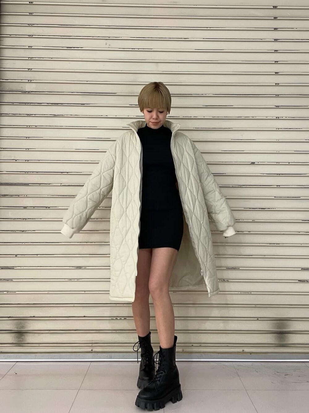 ホワイト系のモッズコート、ブラック系のワンピース、ブラック系のブーツを着用したレディースの春コーディネートの3枚目の写真