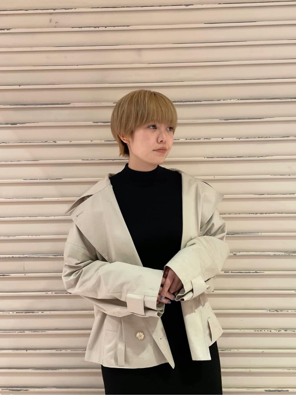 ブラック系のブーツ、ベージュ系のトレンチコート、ブラック系のワンピースを着用したレディースの冬コーディネートの5枚目の写真