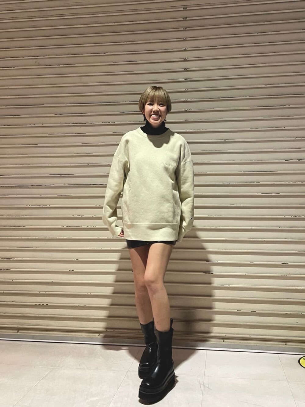 ベージュ系のスウェット、ブラック系のスカートを着用したレディースの冬コーディネートの2枚目の写真