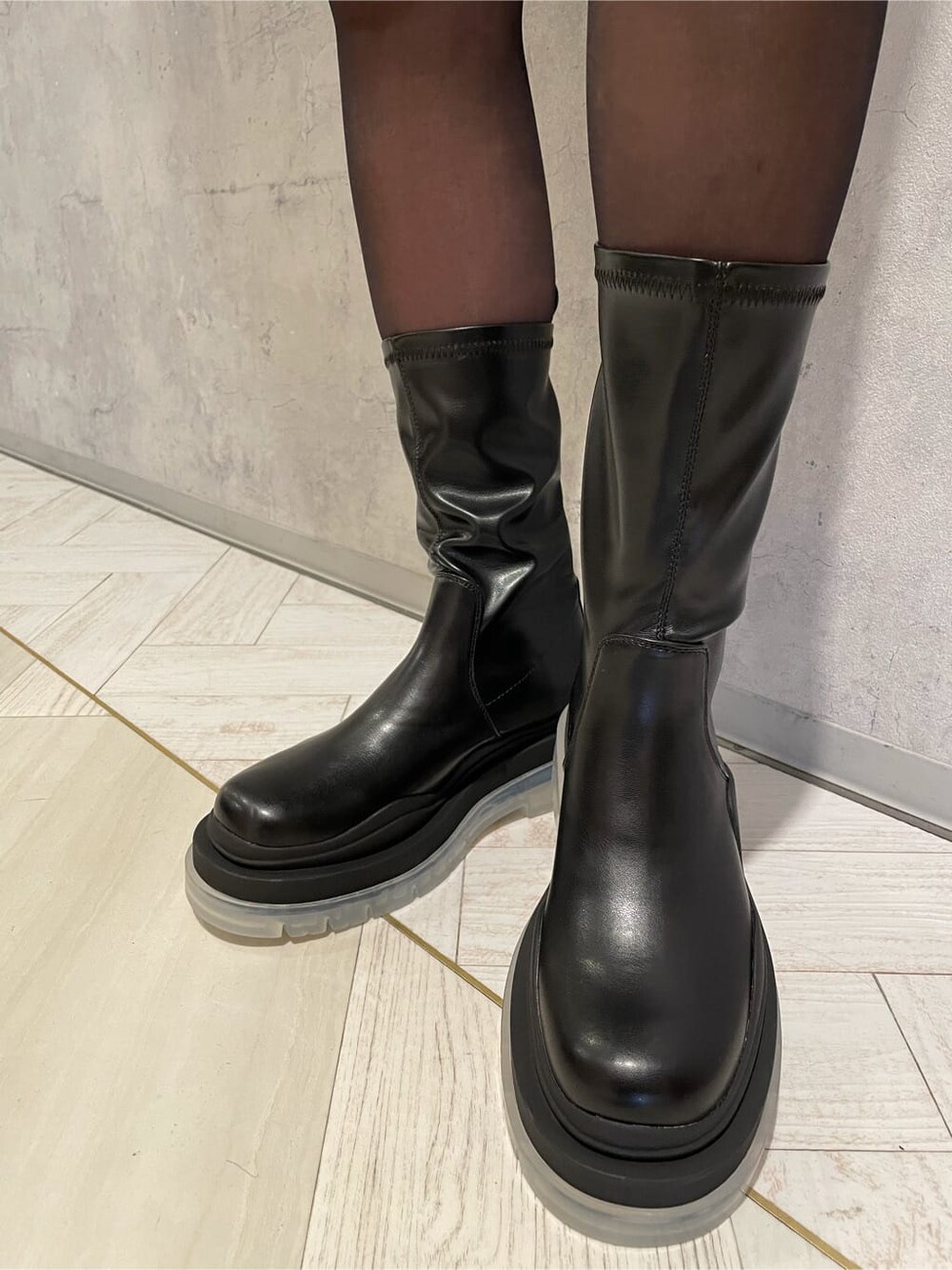 ブラック系のブーツ、ブラック系のスカート、ブラック系のダウンジャケット/コートを着用したレディースの冬コーディネートの7枚目の写真