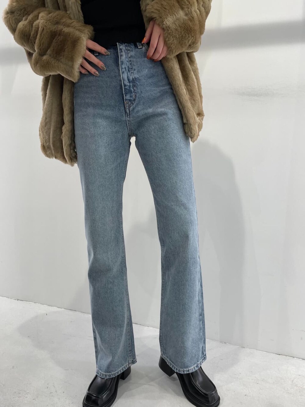 ブラック系のブーツ、ベージュ系のその他アウター、ブラック系のニット/セーターを着用したレディースの冬コーディネートの5枚目の写真