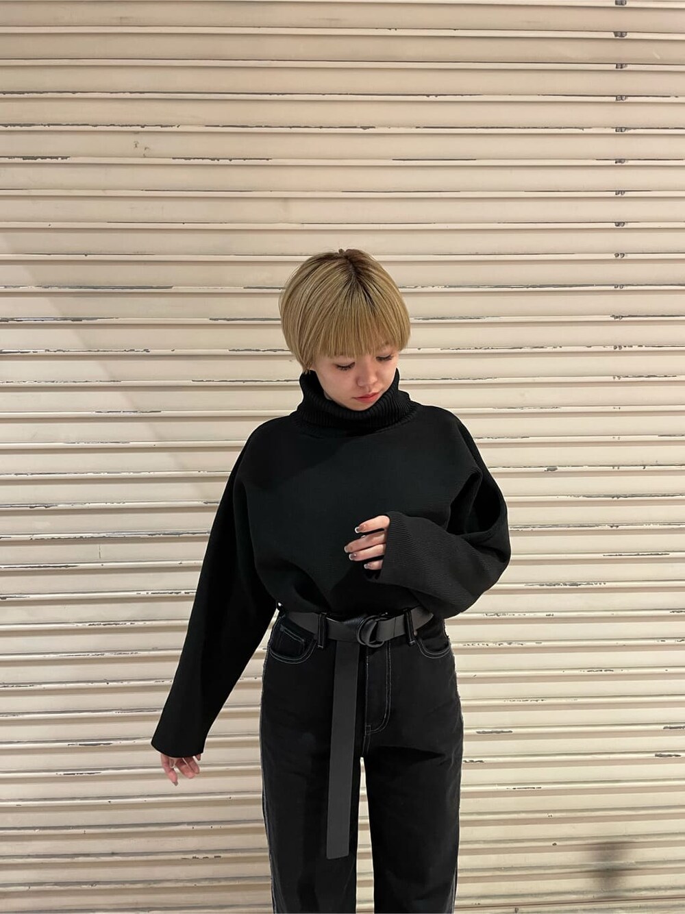 ブラック系のデニムパンツ、ブラック系のニット/セーター、ホワイト系のローファーを着用したレディースの秋コーディネートの5枚目の写真