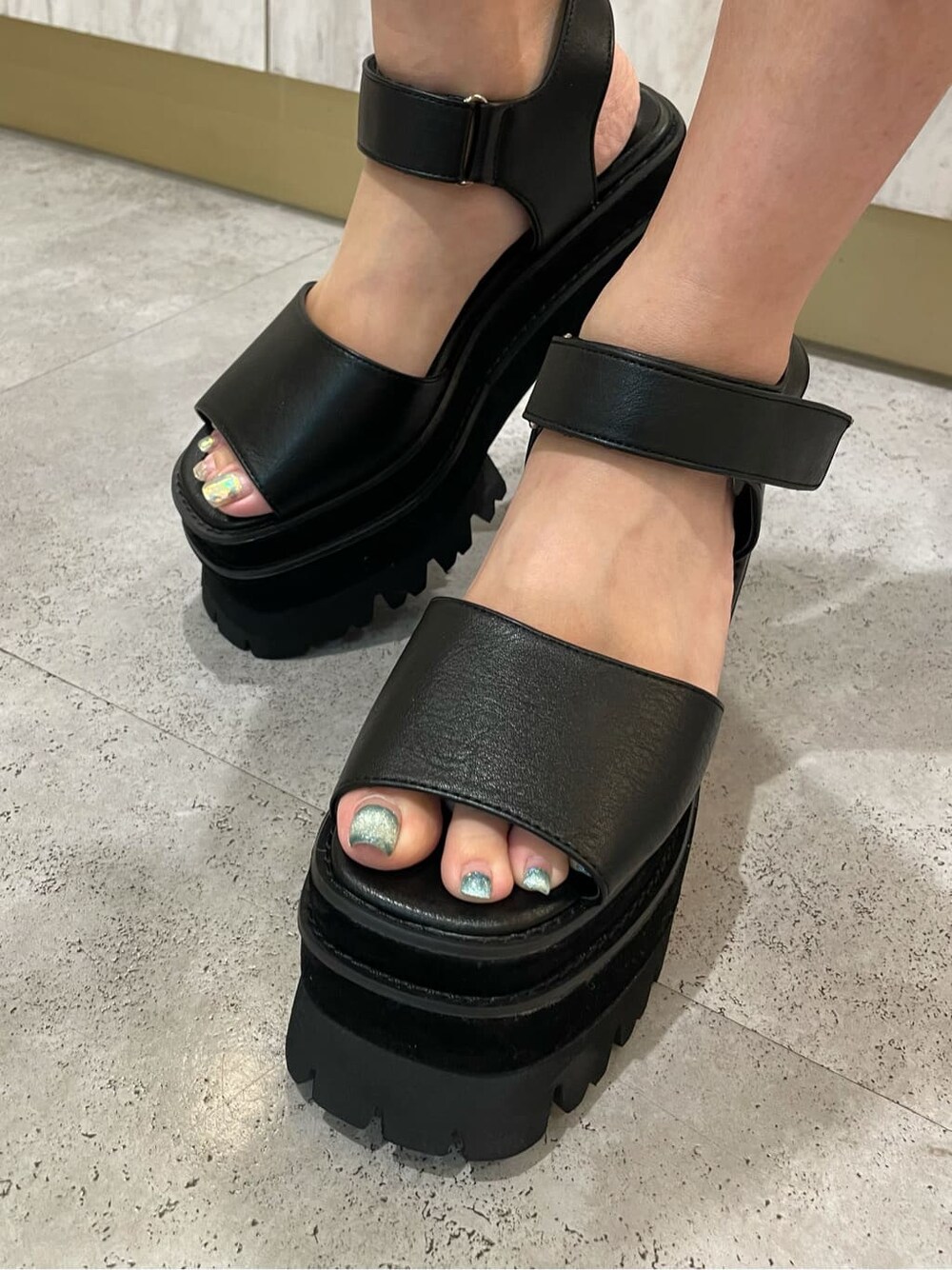 ブルー系のワンピース、ブラック系のサンダル、ブラック系のハンドバッグを着用したレディースの夏コーディネートの8枚目の写真