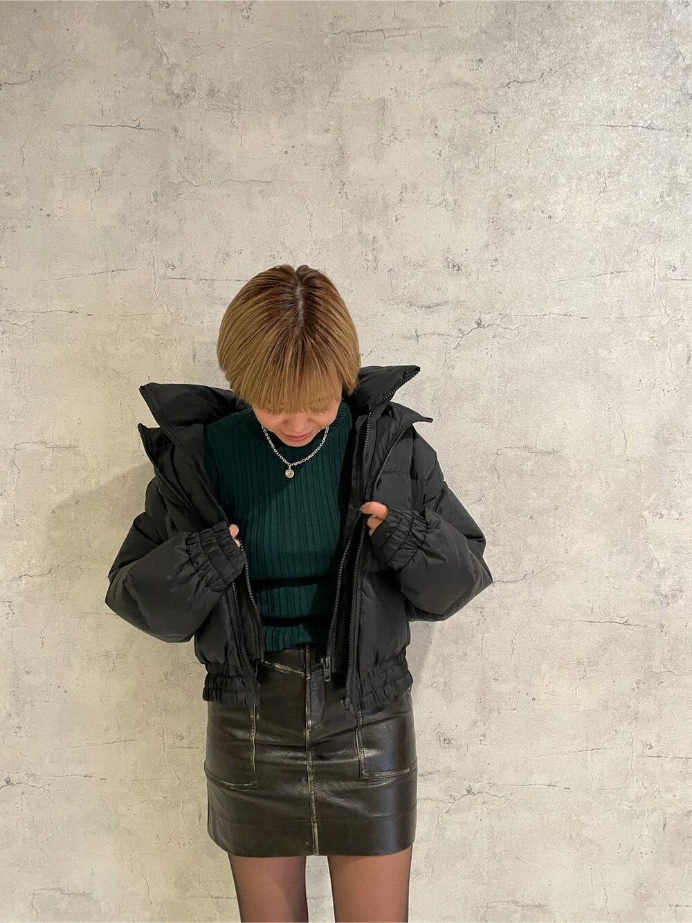 ブラック系のブーツ、ブラック系のスカート、ブラック系のダウンジャケット/コートを着用したレディースの冬コーディネートの5枚目の写真