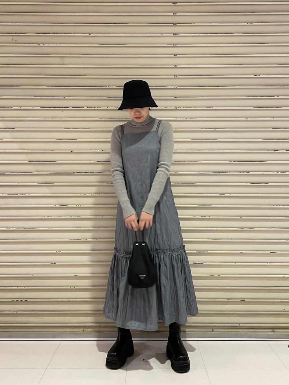 グレー系のニット/セーター、グレー系のワンピース、ブラック系のハットを着用したレディースの冬コーディネートの2枚目の写真