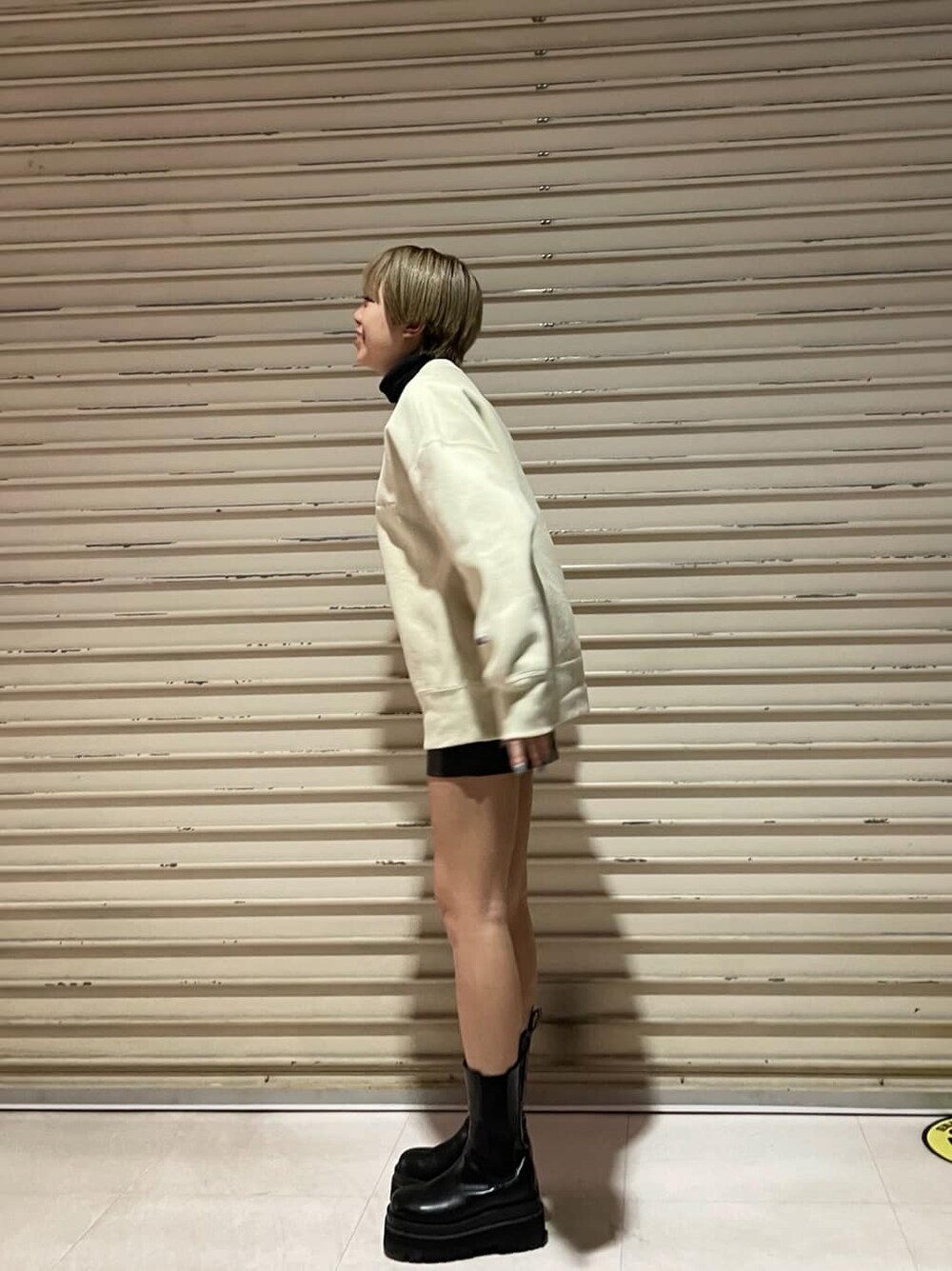 ベージュ系のスウェット、ブラック系のスカートを着用したレディースの冬コーディネートの4枚目の写真