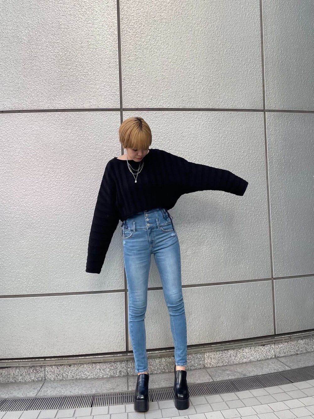 ブラック系のニット/セーター、ブラック系のローファー、ブルー系のデニムパンツを着用したレディースの冬コーディネートの2枚目の写真