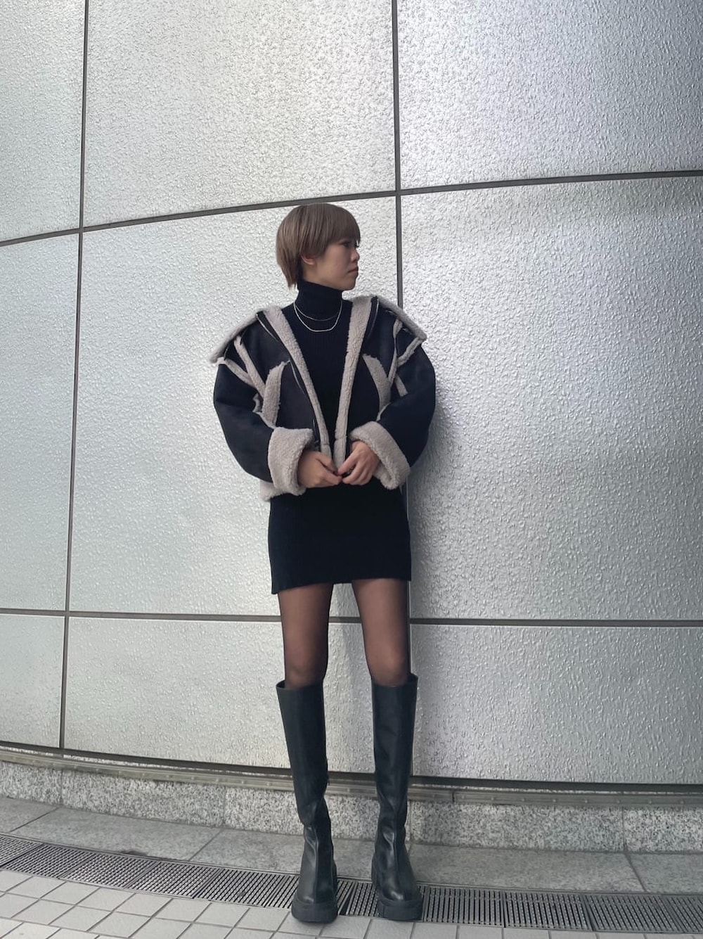 ブラック系のワンピース、その他のムートンコート、ブラック系のブーツを着用したレディースの冬コーディネートの2枚目の写真