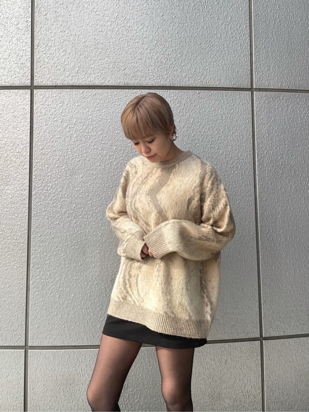 ベージュ系のニット/セーター、ブラック系のスカート、ブラック系のブーツを着用したレディースの冬コーディネートの4枚目の写真