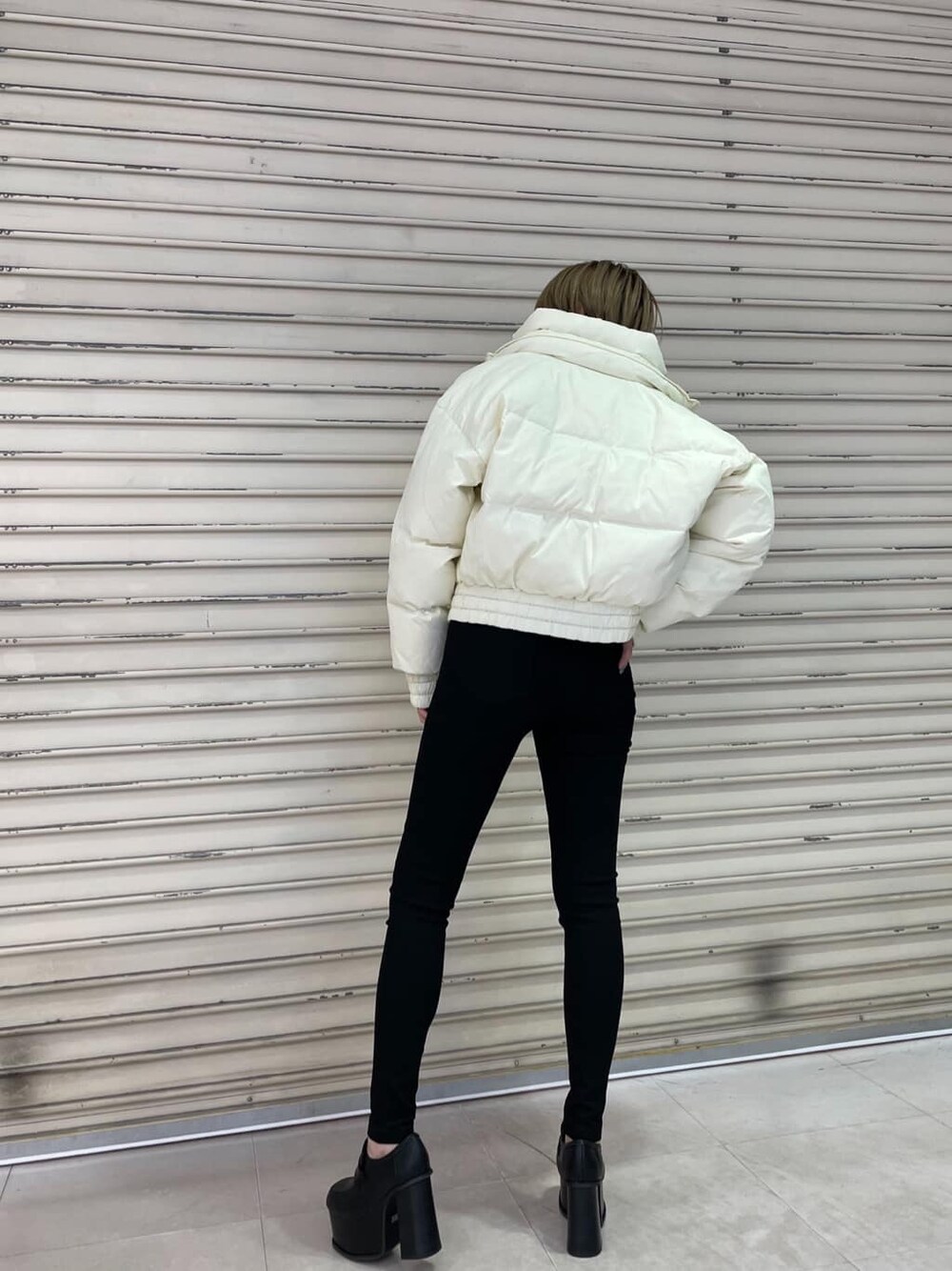 ブラック系のTシャツ/カットソー、ブラック系のデニムパンツ、ブラック系のローファーを着用したレディースの冬コーディネートの4枚目の写真