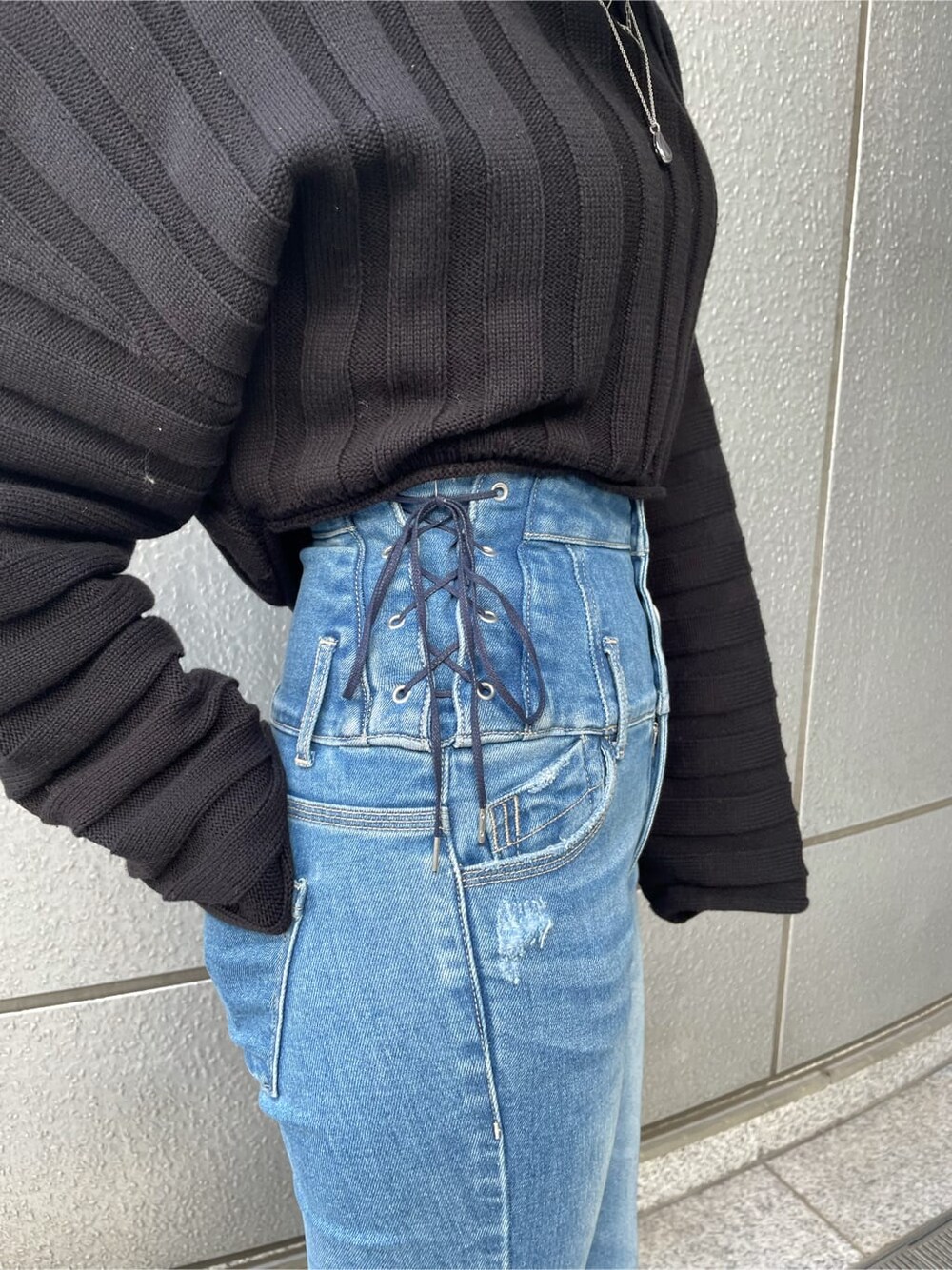 ブラック系のニット/セーター、ブラック系のローファー、ブルー系のデニムパンツを着用したレディースの冬コーディネートの6枚目の写真