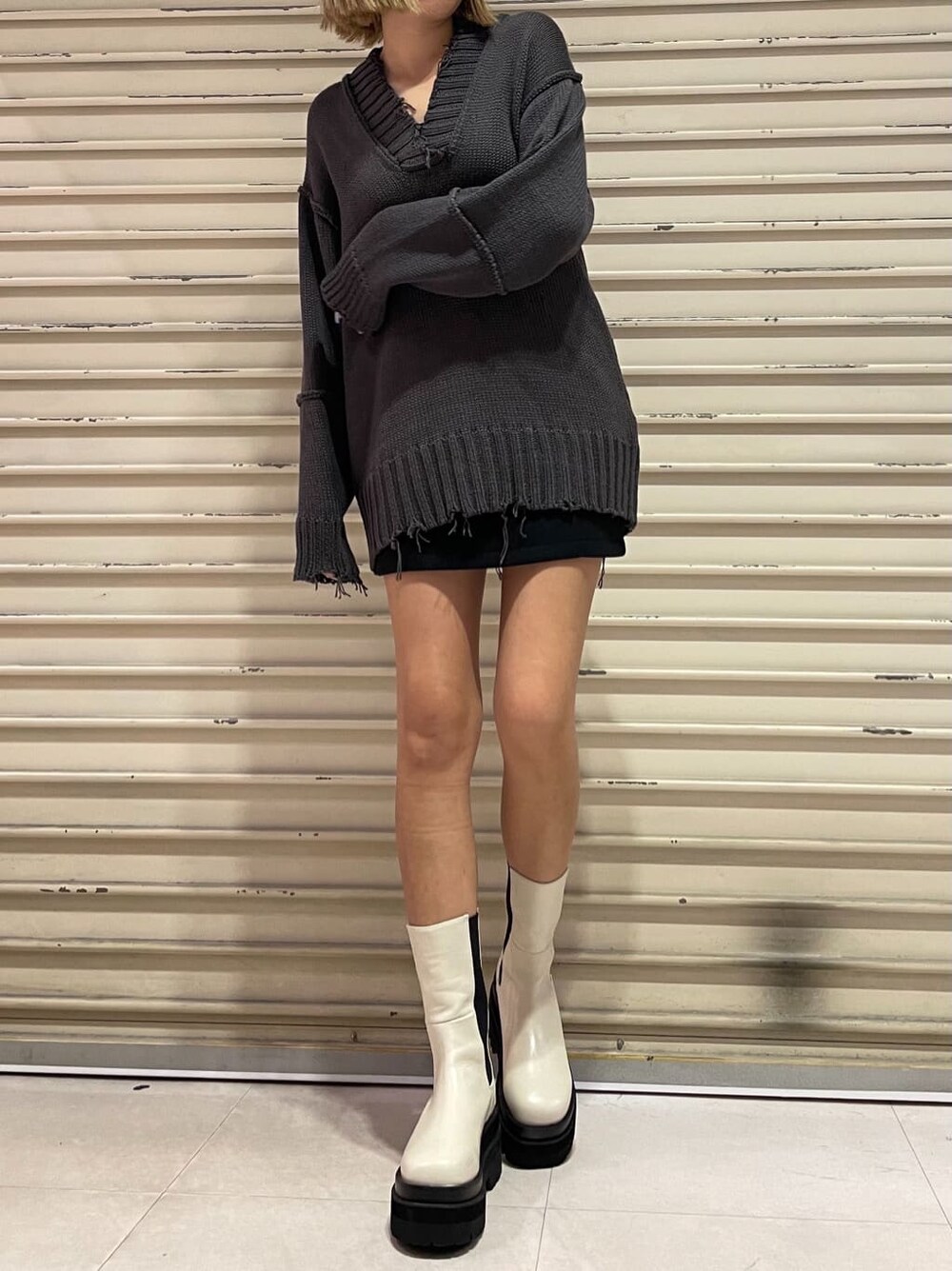 ブラック系のスカート、グレー系のニット/セーターを着用したレディースの秋コーディネートの3枚目の写真