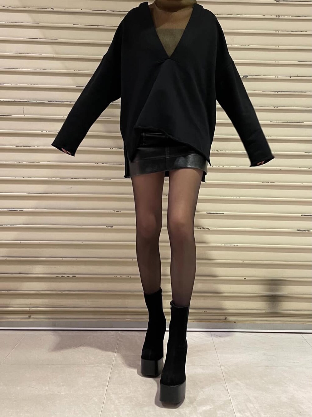 ブラック系のブーツ、ブラック系のスカート、ブラウン系のTシャツ/カットソーを着用したレディースの冬コーディネートの3枚目の写真