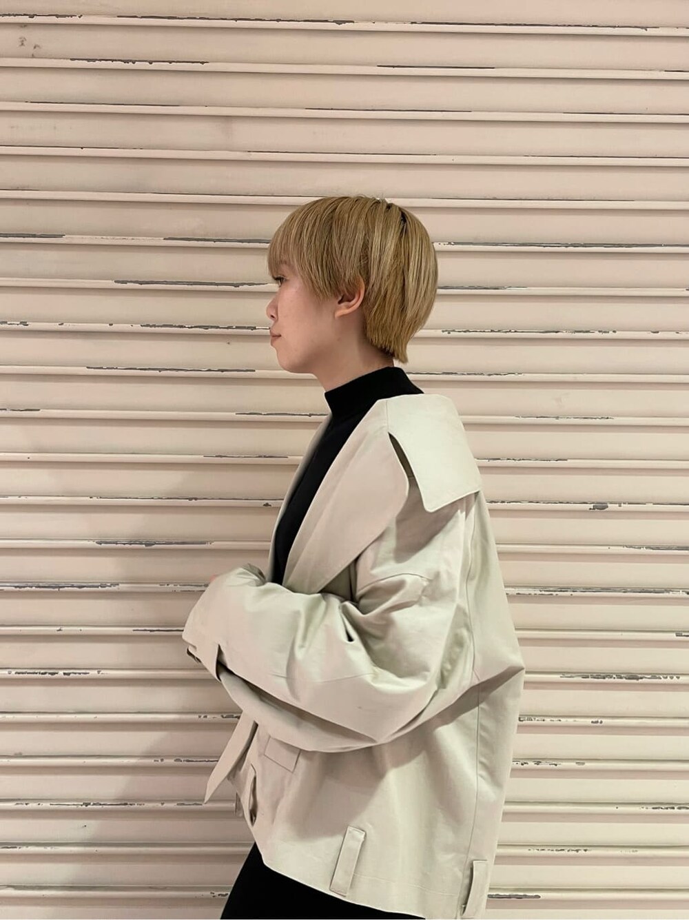 ブラック系のブーツ、ベージュ系のトレンチコート、ブラック系のワンピースを着用したレディースの冬コーディネートの6枚目の写真