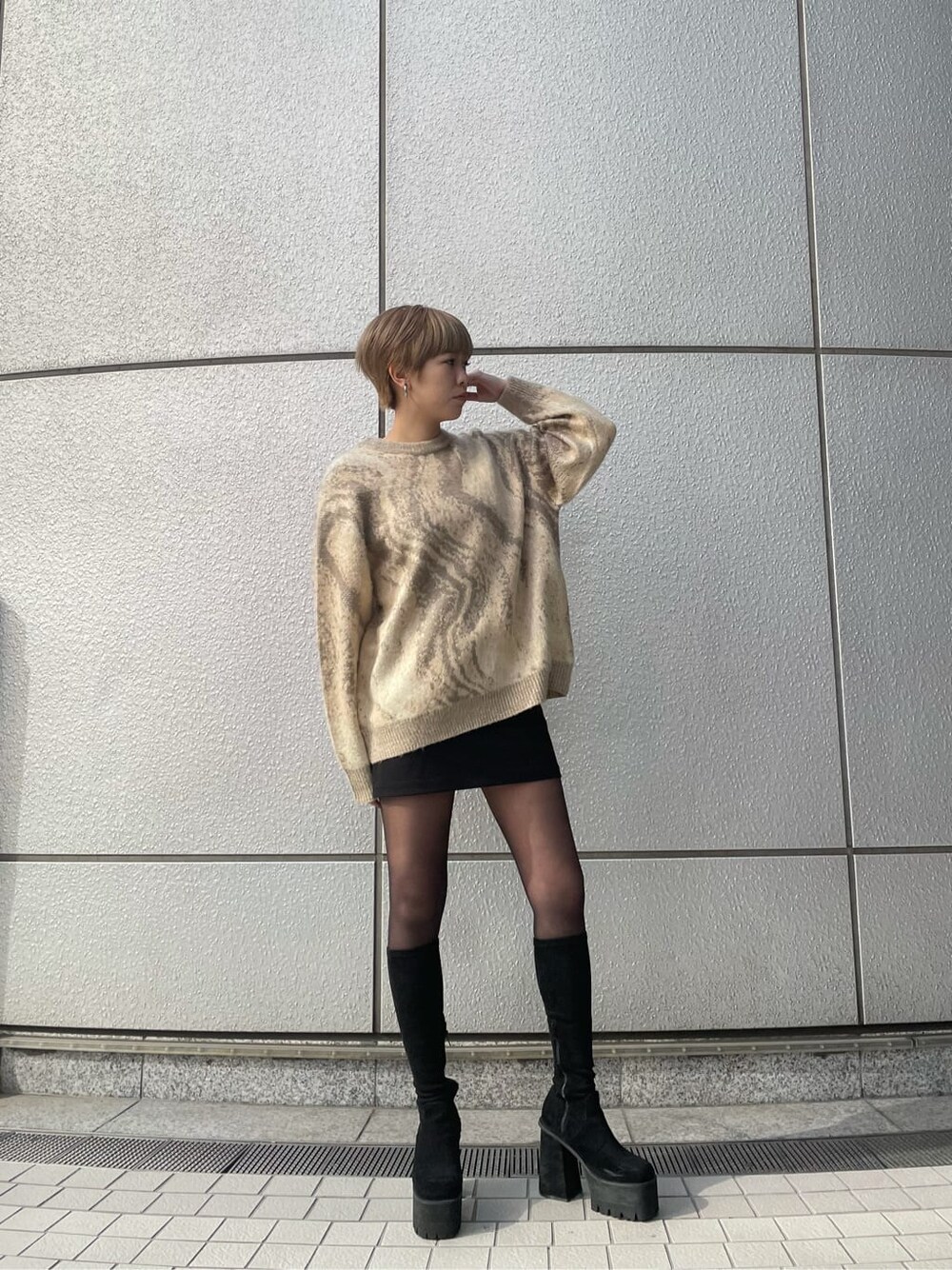 ベージュ系のニット/セーター、ブラック系のスカート、ブラック系のブーツを着用したレディースの冬コーディネートの3枚目の写真