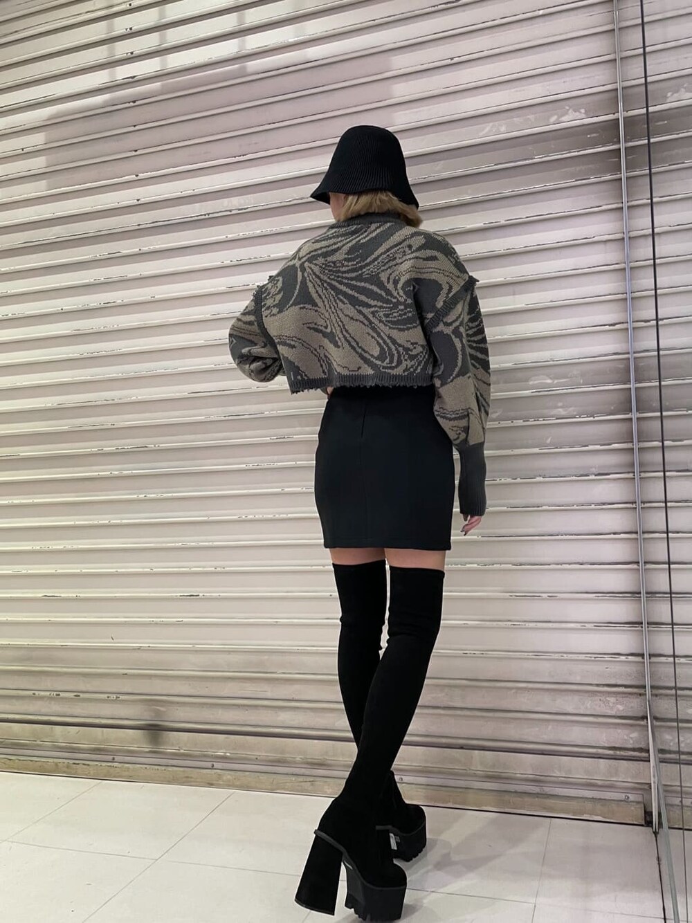 ブラック系のスカート、ブラック系のブーツ、その他のニット/セーターを着用したレディースの秋コーディネートの3枚目の写真