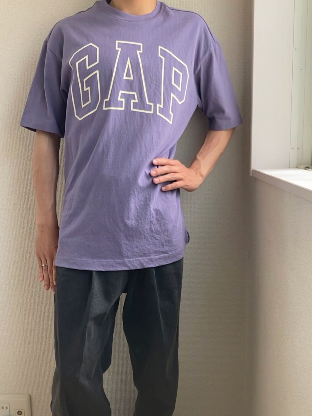 ブラック系のデニムパンツ、パープル系のTシャツ/カットソー、ブラック系のスニーカーを着用したメンズの春コーディネートの3枚目の写真