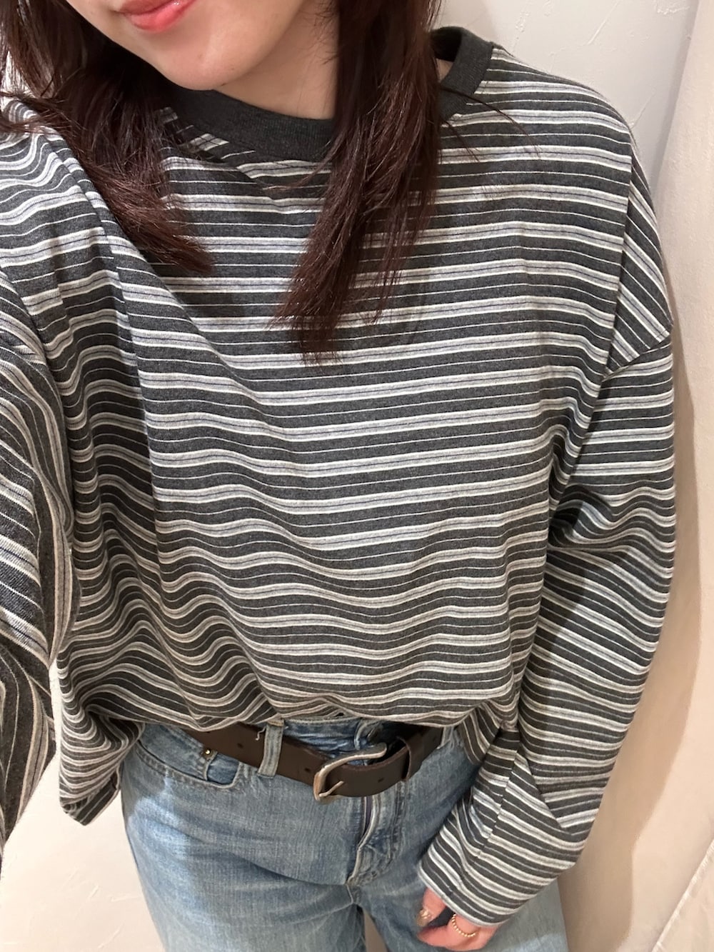 グレー系のTシャツ/カットソー、ブルー系のデニムパンツを着用したレディースの冬コーディネートの5枚目の写真