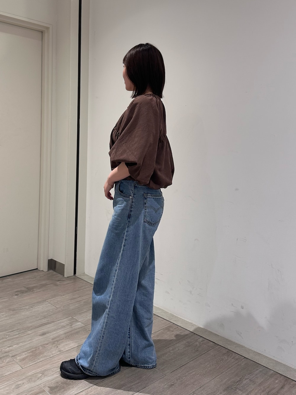 ブラウン系のシャツ/ブラウス、ブルー系のデニムパンツを着用したレディースの秋コーディネートの2枚目の写真
