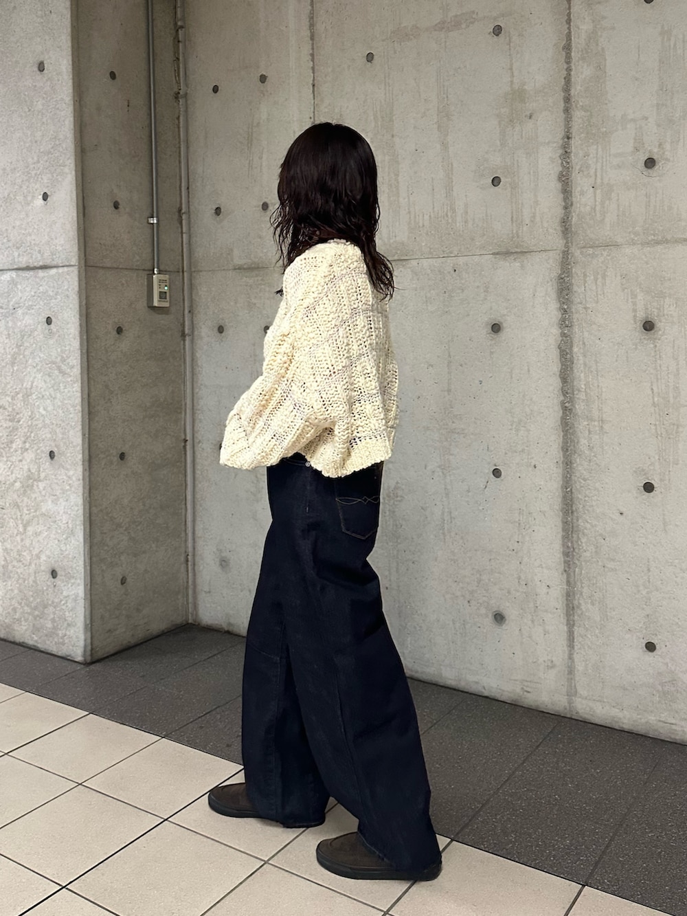 ベージュ系のニット/セーター、ブルー系のデニムパンツを着用したレディースの冬コーディネートの3枚目の写真