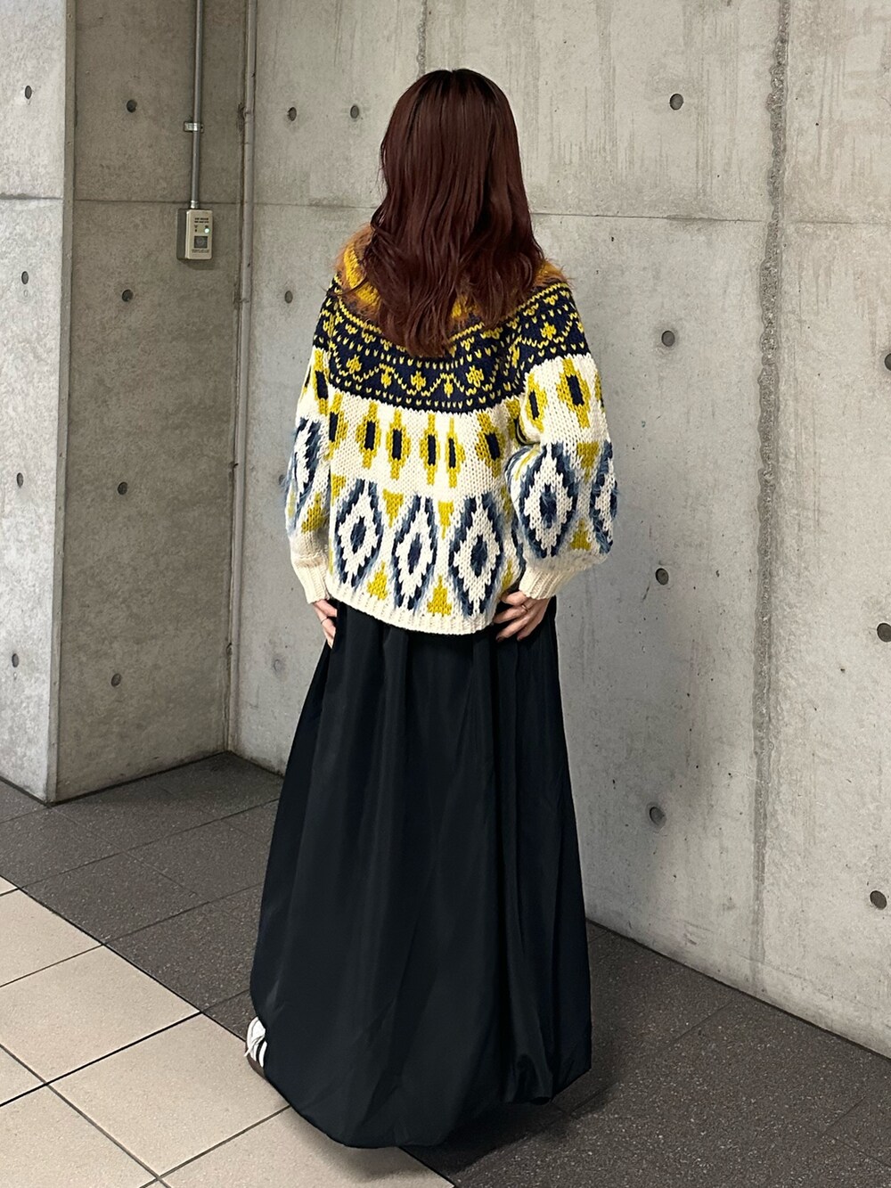 ホワイト系のニット/セーター、ブラック系のスカートを着用したレディースの冬コーディネートの4枚目の写真