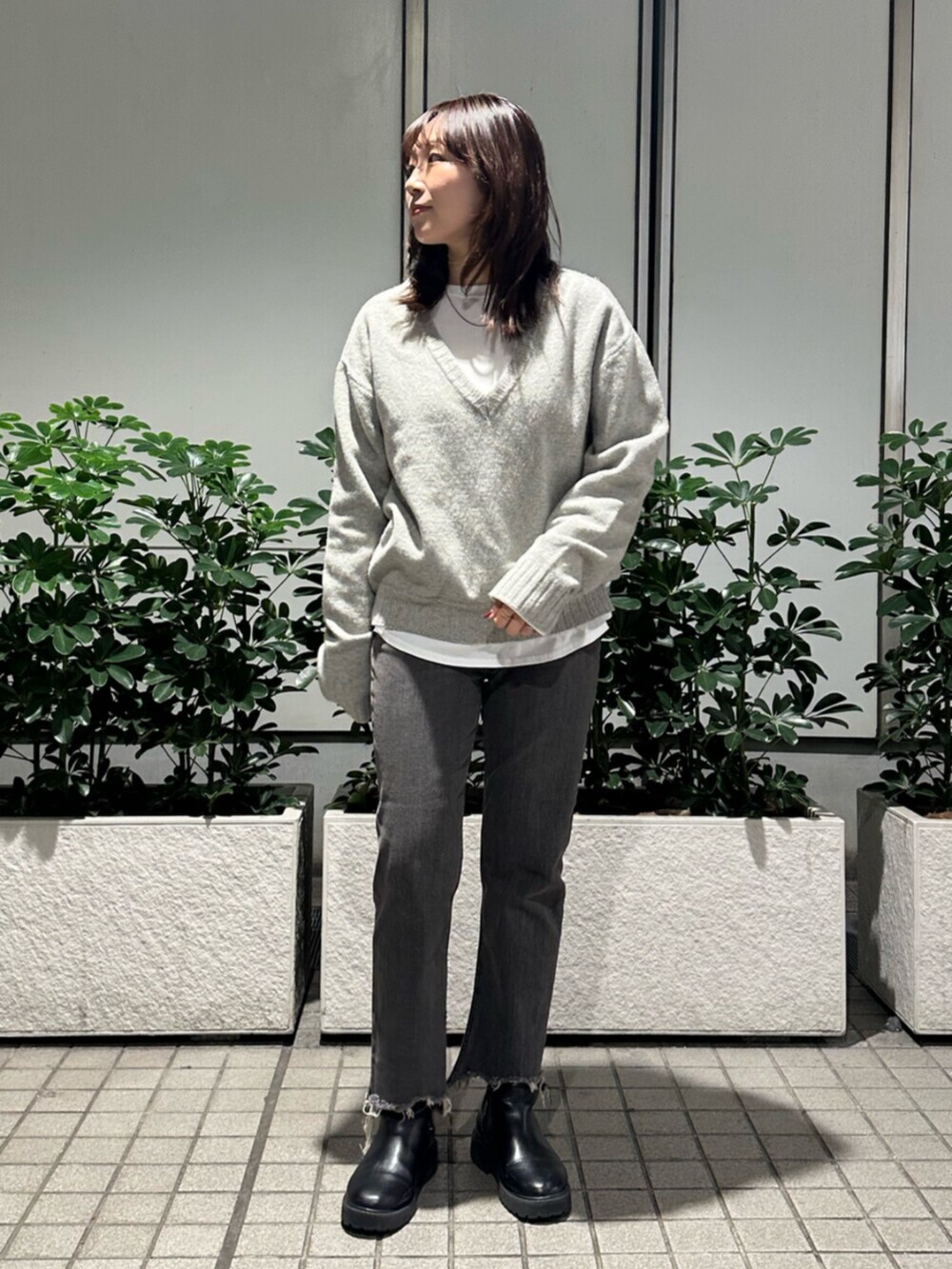 グレー系のニット/セーター、ブラック系のデニムパンツを着用したレディースの秋コーディネートの2枚目の写真