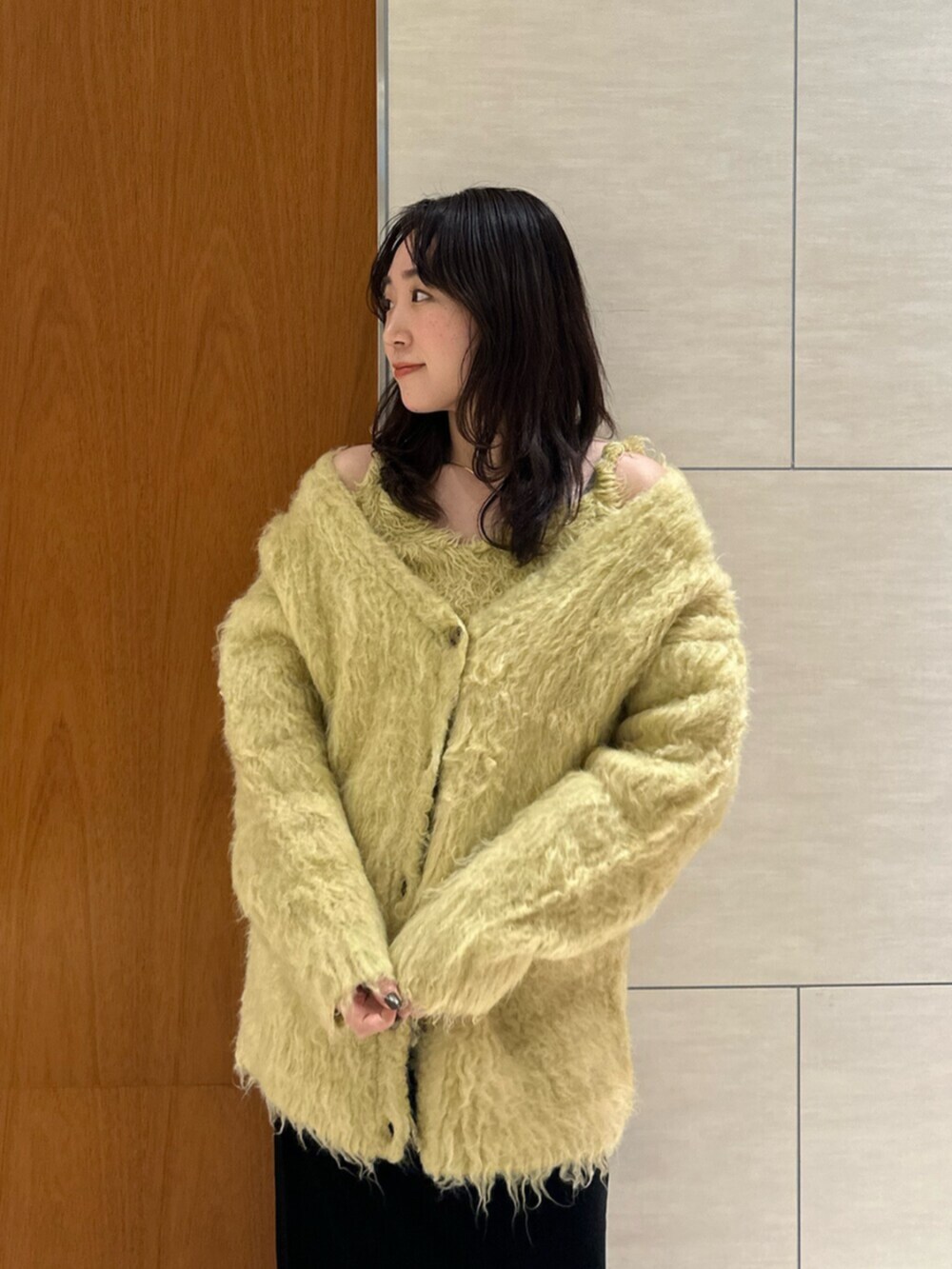 ブラック系のスカート、イエロー系のカーディガン/ボレロを着用したレディースの秋コーディネートの5枚目の写真