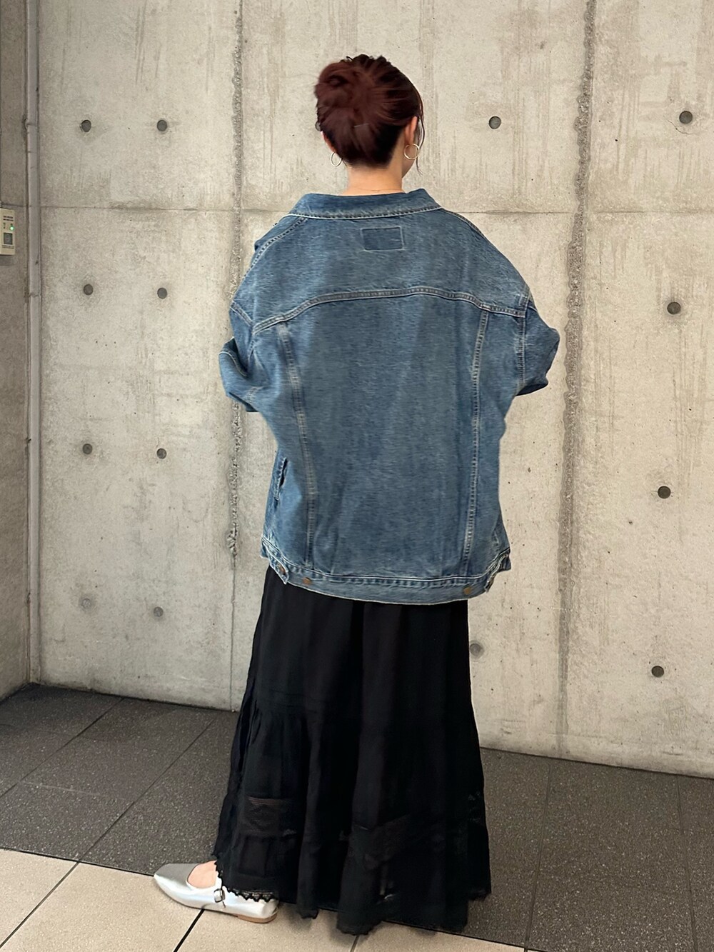 ブルー系のデニムジャケット、ブラック系のスカートを着用したレディースの夏コーディネートの4枚目の写真