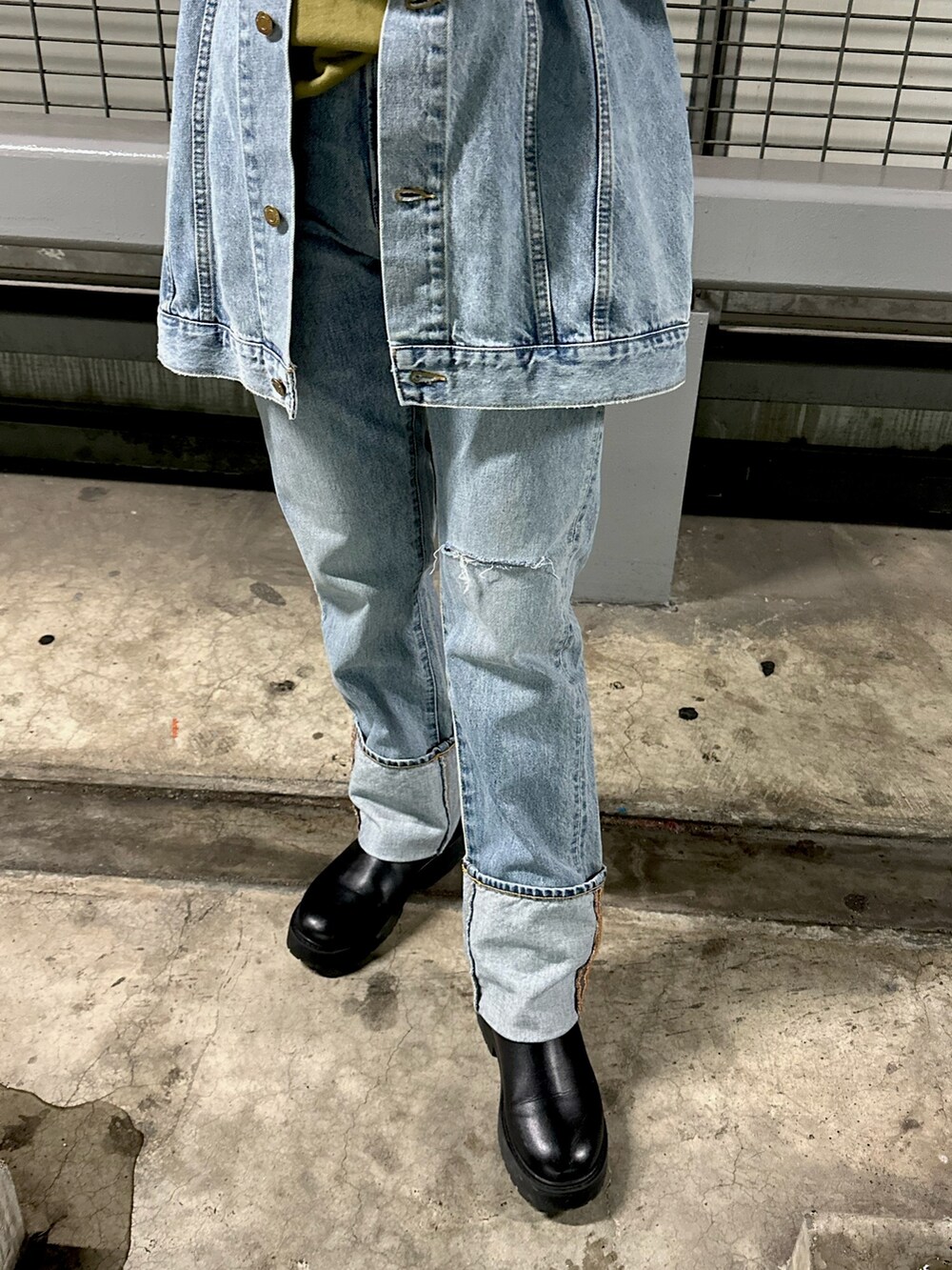 グリーン系のスウェット、ブルー系のデニムパンツを着用したレディースの冬コーディネートの6枚目の写真