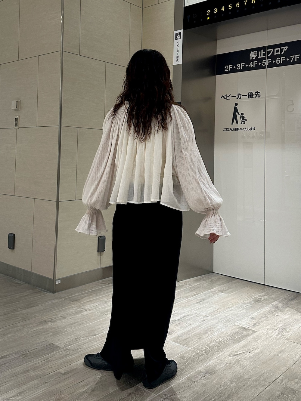 ホワイト系のシャツ/ブラウス、ブラック系のスカートを着用したレディースの秋コーディネートの5枚目の写真