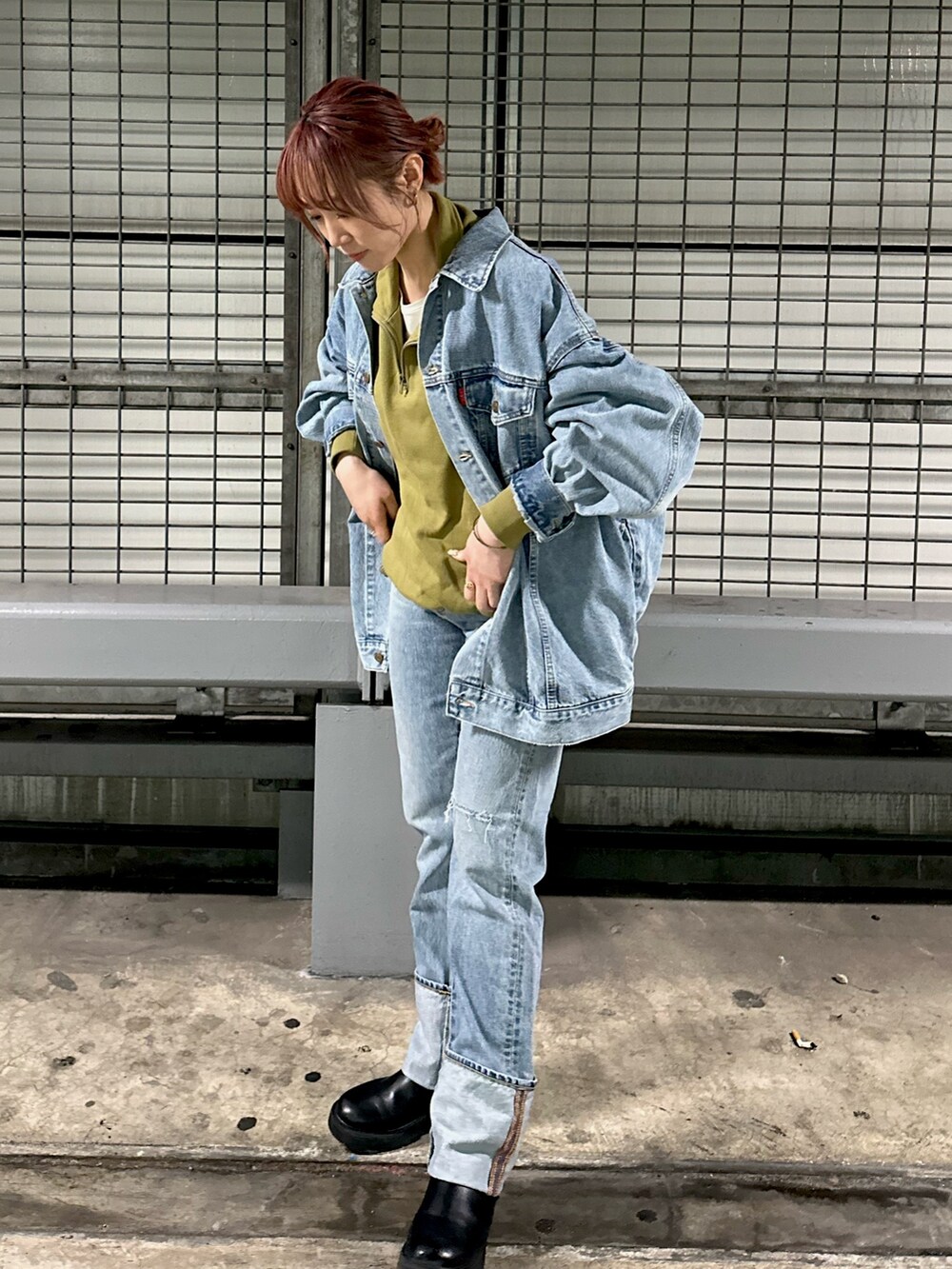 グリーン系のスウェット、ブルー系のデニムパンツを着用したレディースの冬コーディネートの4枚目の写真