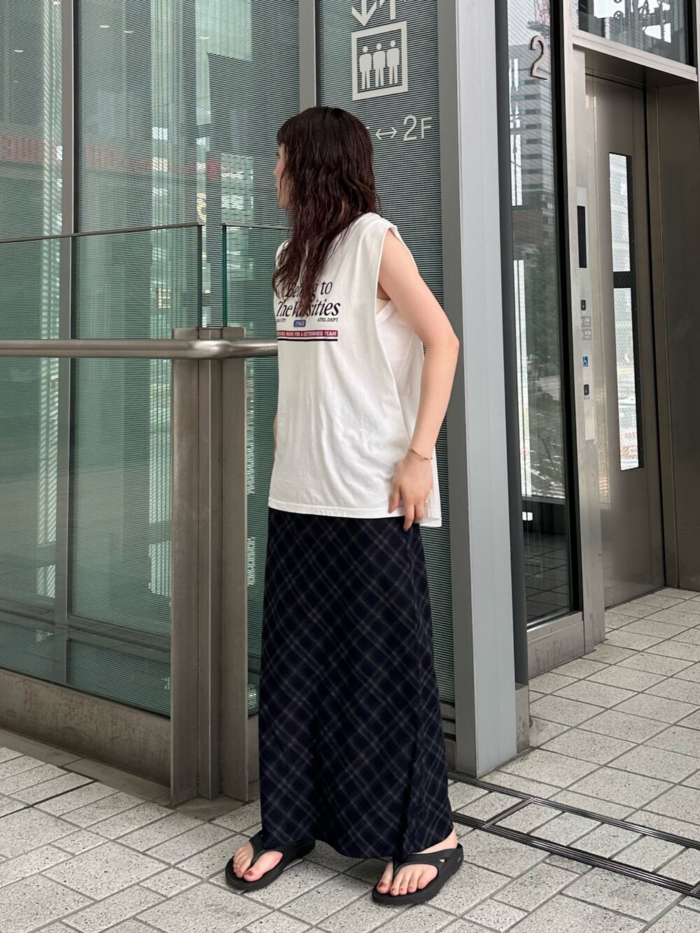 ホワイト系のタンクトップ、ブルー系のスカートを着用したレディースの夏コーディネートの3枚目の写真