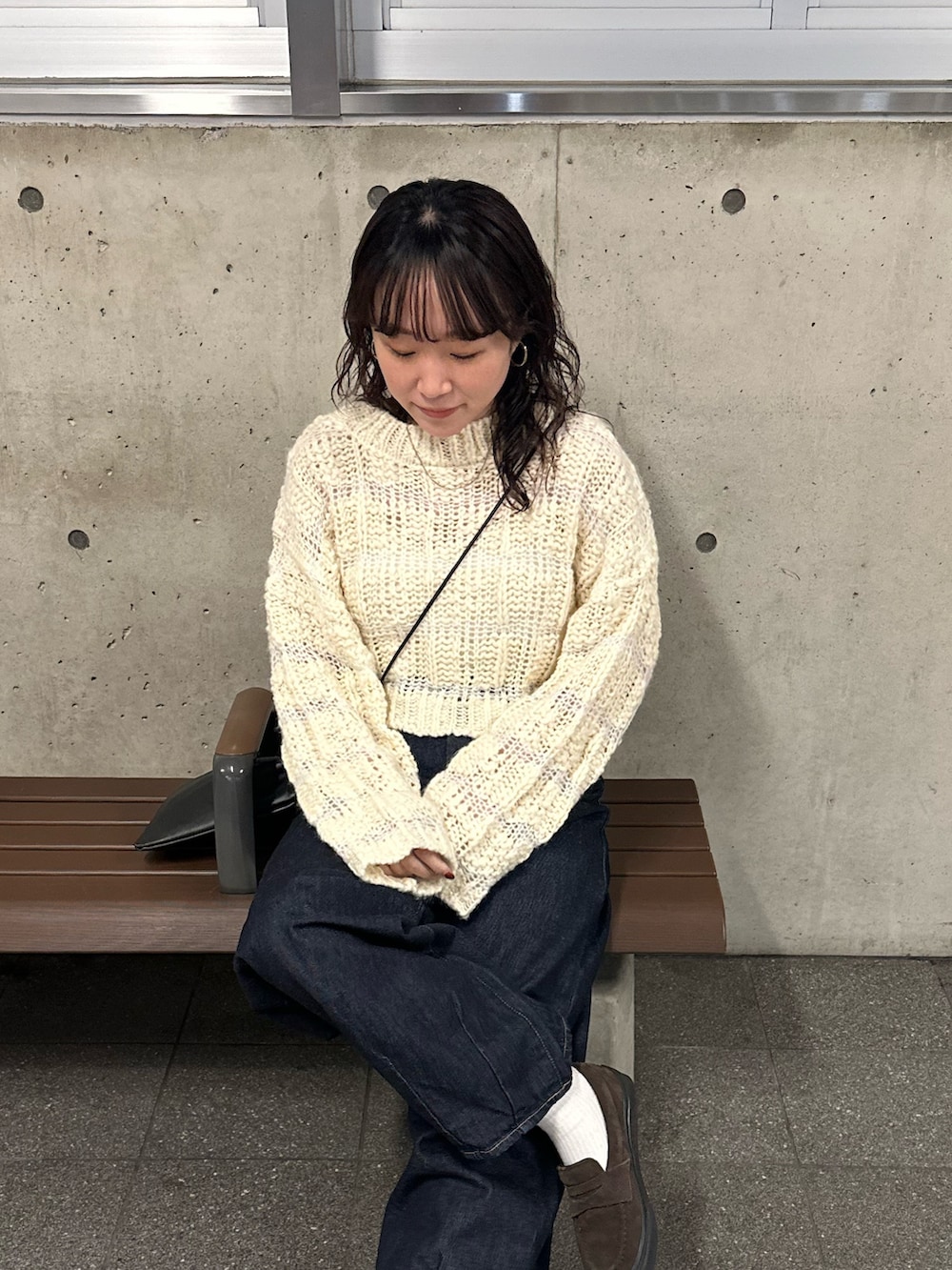 ベージュ系のニット/セーター、ブルー系のデニムパンツを着用したレディースの冬コーディネートの5枚目の写真