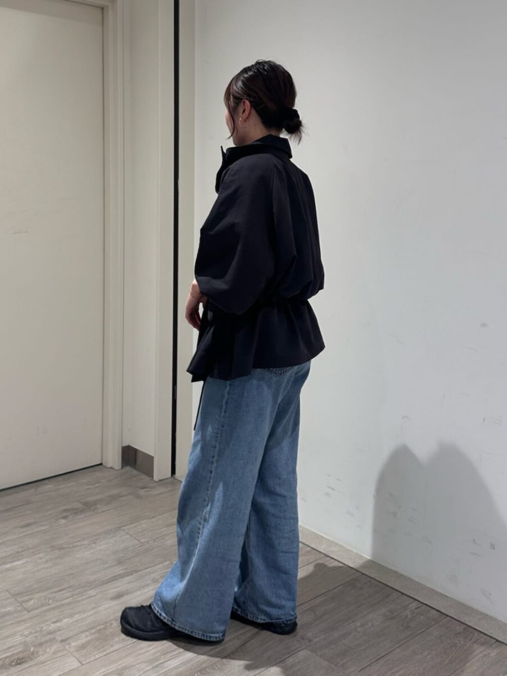 ブルー系のデニムパンツ、グレー系のトレンチコートを着用したレディースの秋コーディネートの3枚目の写真