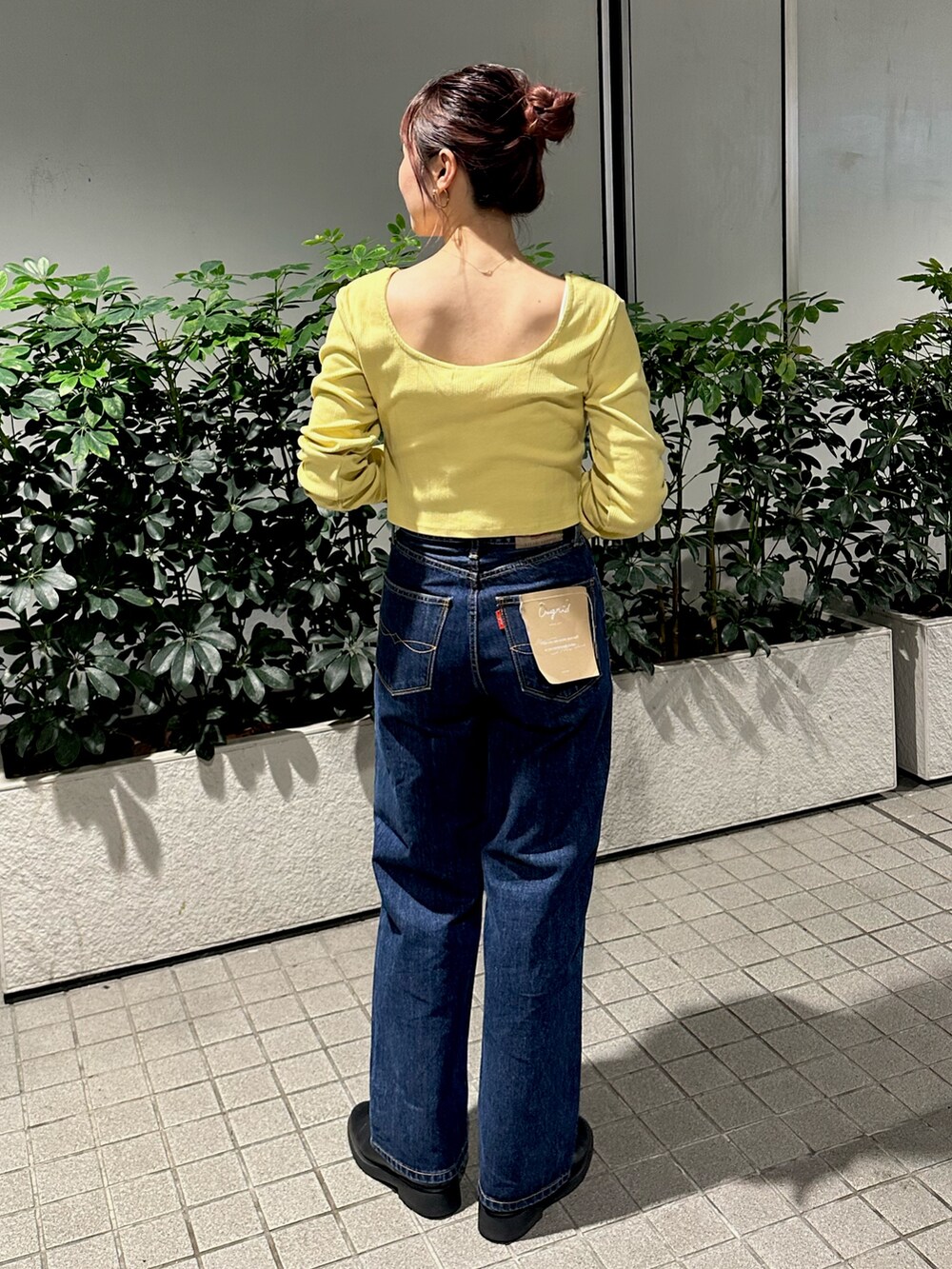 グリーン系のTシャツ/カットソー、ブルー系のデニムパンツを着用したレディースの秋コーディネートの3枚目の写真