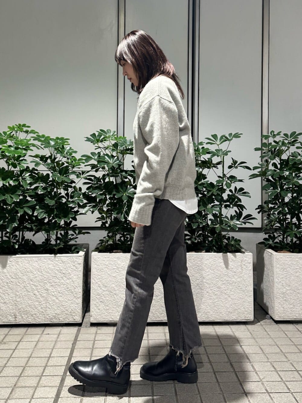 グレー系のニット/セーター、ブラック系のデニムパンツを着用したレディースの秋コーディネートの4枚目の写真