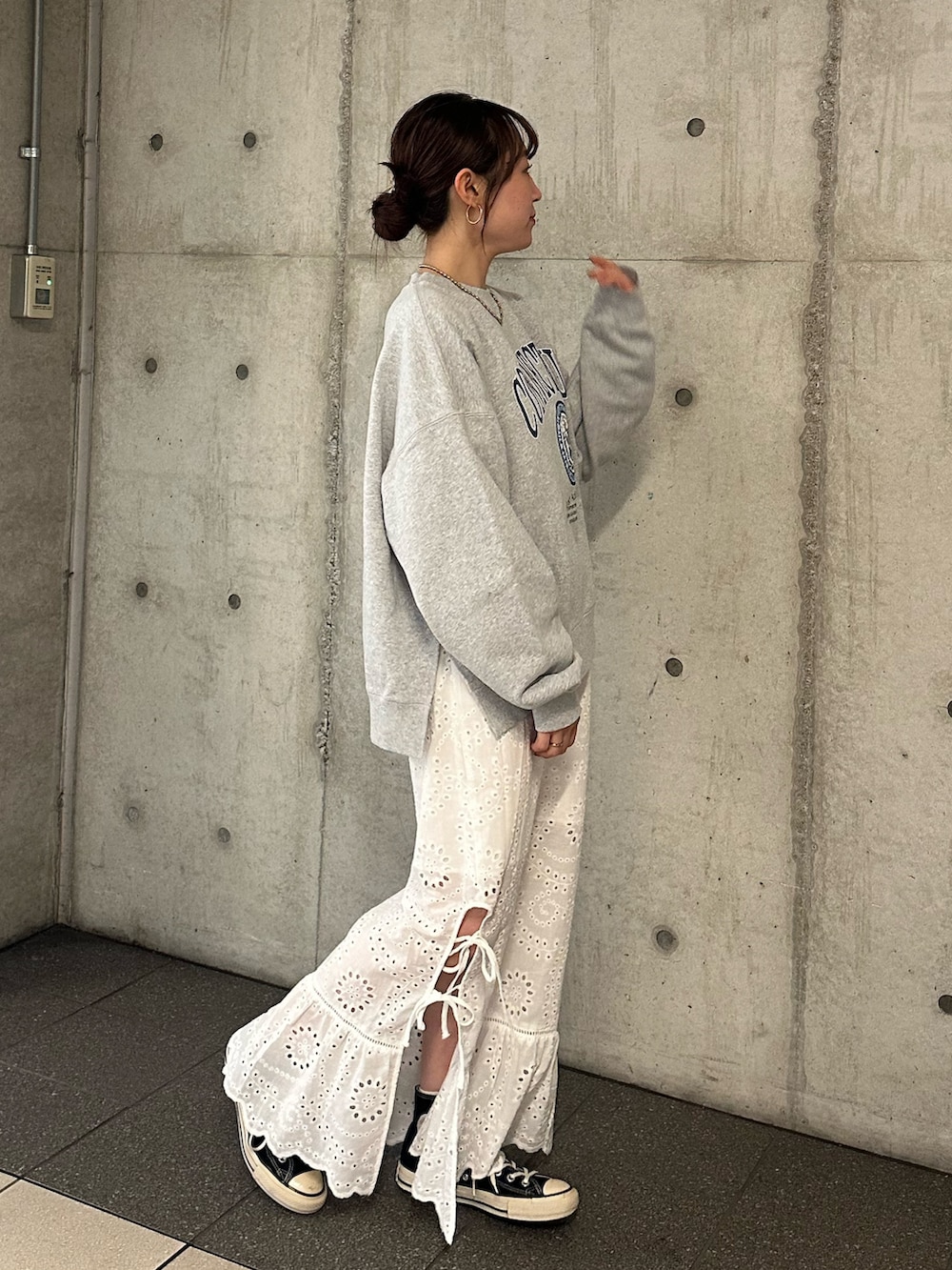 グレー系のスウェット、ホワイト系のスカートを着用したレディースの冬コーディネートの3枚目の写真