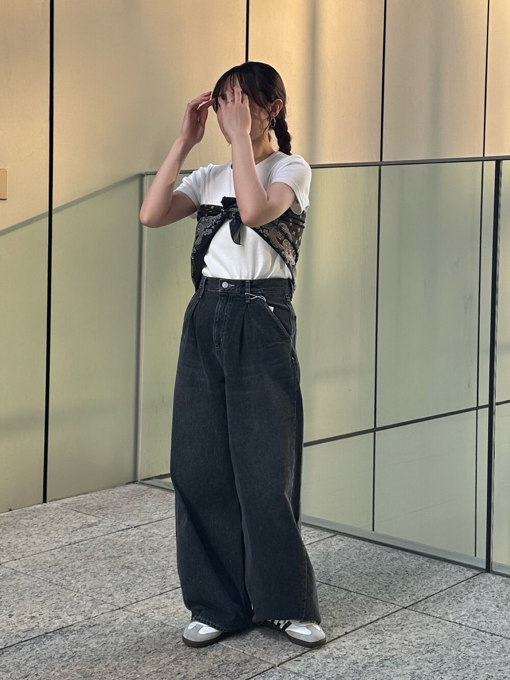 ホワイト系のTシャツ/カットソー、ブラック系のデニムパンツ、ブラック系のストール/ショールを着用したレディースの春コーディネートの6枚目の写真